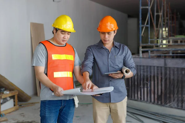 İnşaat mühendisi ve mimar inşaat alanında mavi baskı ile çalışma kavramı