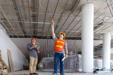 İnşaat mühendisi ve mimar inşaat alanında mavi baskı ile çalışma kavramı