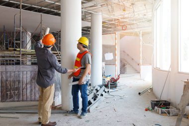 İnşaat mühendisi ve mimar inşaat alanında mavi baskı ile çalışma kavramı