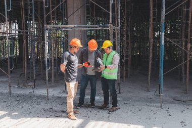 İnşaat mühendisi ve mimar inşaat alanında mavi baskı ile çalışma kavramı