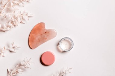 Guashe, gül kuvarslarından ve soluk pembe arka planda nemlendirici jellerden, süslenmiş beyaz kuru çiçeklerden kazır. Yüz için doğal taş masaj aleti, lenfatik drenaj masajı ev yaşam tarzı sağlığı..