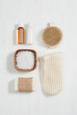Beyaz ahşap arka planda güzellik ve vücut bakımı için spa seti. Jöleli ve şampuanlı şişeler, sabun, deniz tuzu, banyo için bez..