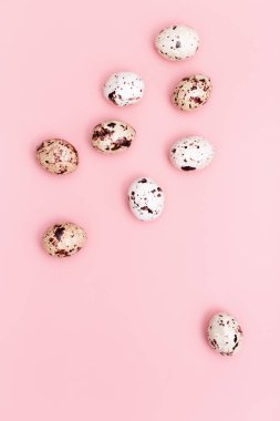 Süslü Paskalya yumurtaları, yumuşak pembe arka planda çikolatalı şekerler. Bahar Tatili Düzlüğü kompozisyonu.