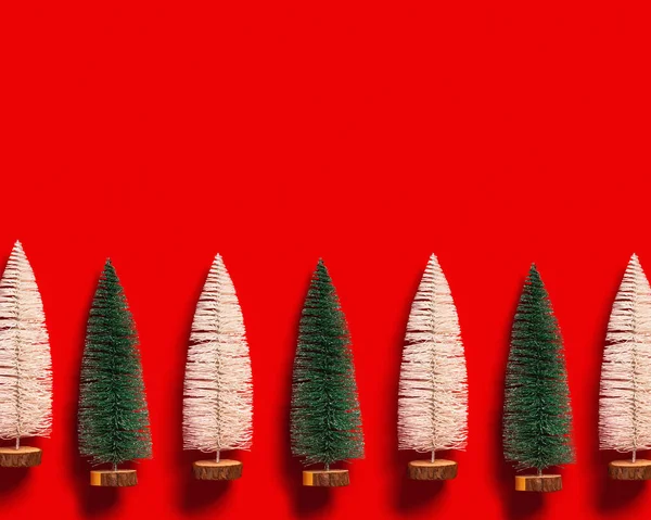 Árvore de Natal cores verdes e brancas no fundo vermelho. O apartamento mínimo brilhante do ano novo coloca com abeto festivo plástico, conceito do inverno do feriado — Fotografia de Stock