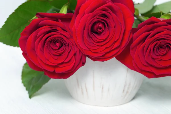 Váza Kyticí Červených Růží Bílém Dřevěném Stole Krásné Červené Pupeny — Stock fotografie