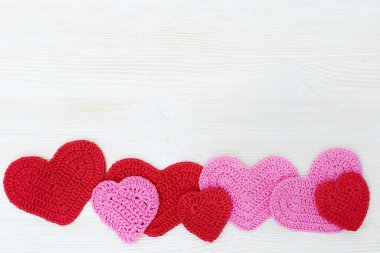 Ahşap arka planda pembe ve kırmızı kalp. Doğum günü, düğün ya da Noel konsepti için el yapımı kalpler.