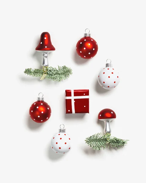 圣诞图案与植物装饰品飞行玛瑙蘑菇与红帽 白色圆点和圣诞球 绿色冷杉枝条 红色礼品盒白色背景 寒假装潢 — 图库照片
