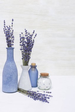 Lavanta aromaterapisi. Lavanta çiçekli kaplıca arka planı ve şişede gerekli yağ. Boşluğu kopyala.