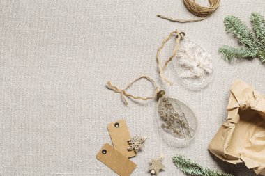 Kurumuş çiçekleri, otları dolduran incik boncuklar. Kırsal kumaş arka planında cam Noel süsleri. Yeni yıl hediyesi ya da dekorasyon iç mimari fikri, xmas botanik topları, yaratıcı düz yatak