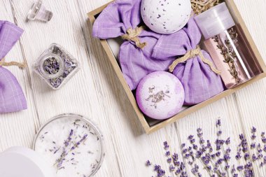 Gevşemek için lavanta yağı ve el yapımı hediye olarak stres giderici ürünler ya da ahşap masada sunulan kutu. Spa ve vücut bakımı için doğal lavanta aromaterapisi