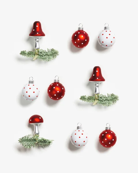 Modèle de Noël avec des ornements botaniques volent champignons agariques avec casquette rouge et points blancs et boules de Noël, branches naturelles de sapin vert sur fond blanc. Décor d'hiver vacances — Photo