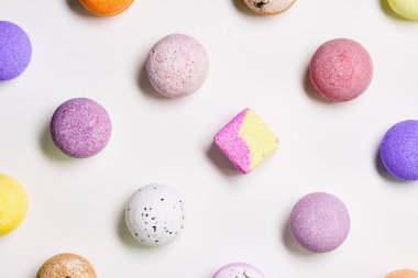 Beyaz kâğıt üzerinde renkli banyo bombaları olan desen. Rahatlamak ve aromaterapi için gerekli yağ ile banyo topları. Vücut bakımı doğal ürünler. Spa için renkli kozmetik bombası