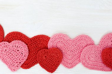 Romantizm konsepti. Doğal ahşap yüzeydeki kırmızı ve pembe kalplerin çerçevesi. Sevgililer Günü arkaplanı