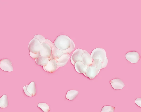Két szív rózsaszirmokból, nagy és kicsi szív fehér virágszirmokból rózsaszínen. Minimális Valentin-napi kártya vagy háttér február 14-re. Ünnepi Valentin napi fogalom. Lapos fektetés — Stock Fotó