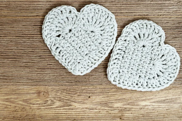 Two white knitted hearts on old wooden background. Beautiful handmade heart on natural surface, soft heart toy. Horizontal format. Top view. Cute present. Love concept. — Stock Photo, Image