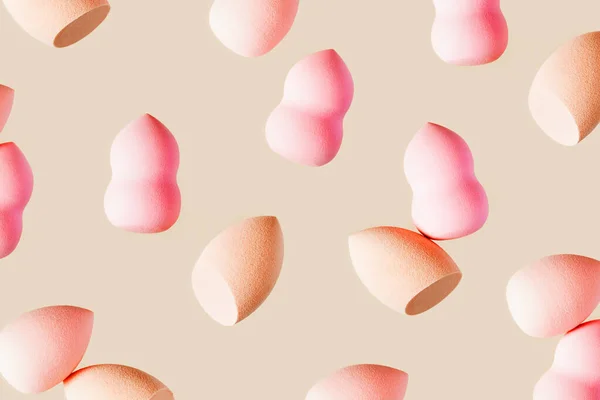 Pattern with cosmetic sponge pink beige colored. Soft makeup sponge beauty blender, brush for face skin, facial applicator. Backgrounds for salon fashion beauty makeup — Stockfoto