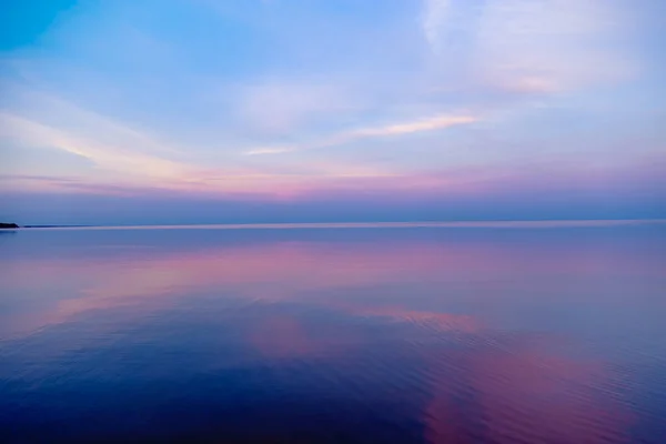 Beautiful sunset on sea, pastel colors and reflections on water, calm nature landscape with colorful clouds — Stock Photo, Image