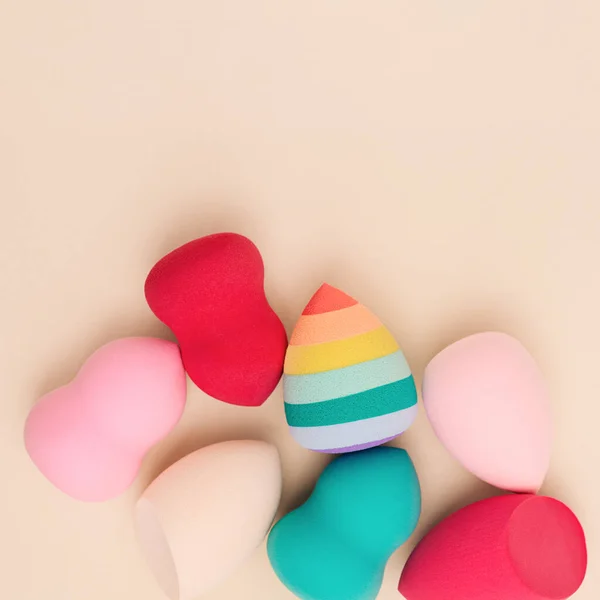 Color cosmetic beauty blender sponges on beige background Professional sponges different shape —  Fotos de Stock