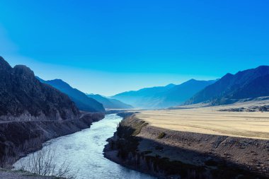 Baharın başında mavi dağ tepeleri ve tonsal perspektifleri. Altai Cumhuriyeti, Altai dağları, Rusya 'daki soyut panoramik manzara. Mavi açık gökyüzü, dağlar ve nehir, doğa ortamı