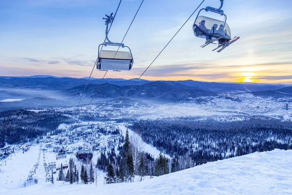 Vue depuis le sommet du mont sur la station de ski Sheregesh et les montagnes de l'Altaï ou Gornaya Shoria. Repos d'hiver actif, skieurs et snowboarders sur piste de ski et remontées mécaniques, nature et loisirs sportifs. — Photo