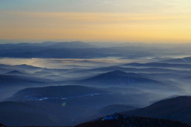 Renkli dağ tepeleri kış akşamında gün batımında tonsal perspektifle. Gornaya Shoria 'daki soyut panoramik manzara, Rusya' daki Sheregesh kayak merkezi Foggy Dağları doğa arka planı
