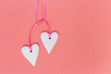 Kağıt arka planda iki beyaz kalp. Düğün ya da Sevgililer Günü için tatil konsepti.