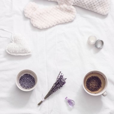 Yatmadan önce dinlenmek için fincanda sağlıklı bitkisel lavanta çayıyla yatıyordu. Uyku maskesi ve yağlı balsam.