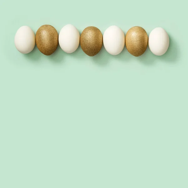 Gedecoreerde paaseieren met gouden en witte eieren op groene achtergrond. Gelukkige Pasen, ansichtkaart, sjabloon — Stockfoto