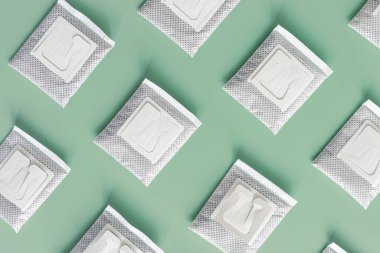 Kahve poşetlerini fincanda demlenmek için öğütülmüş kahveyle doldurun, kağıt torba ile paketleyin nane rengi arka planda kahve filtresi, üst görünüm, en az düz alan, geometrik desen, pastel renkler