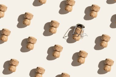 Şampanyalı şampanyalı şablon, bej arka planda sert ışık ve güneş ışığında gölge. Köpüklü şarap ve metal telden yapılmış şişe kapağı motifli trend düzeni, üst görünümü tekrarla, düz yat