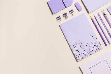 Defterli çerçeve çok peri modası renkli ve kalem, kalem, ataç, okul kırtasiyesi. Bej arka plan konseptine geri dönelim, kopyalama alanı. Ofis malzemeleri güvertede, geometrik düz pankart serili