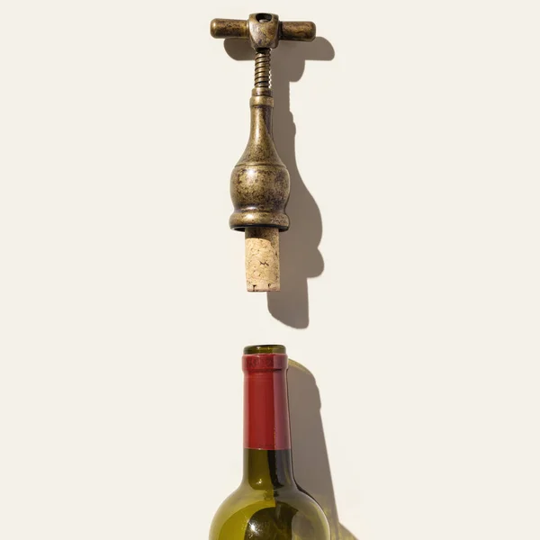 Minimaal bovenaanzicht vintage kurkentrekker met ontkurkte kurk en glazen fles voor rode wijn, conceptontwerp voor wijnkaart op beige ondergrond. Flesschroef of opener met schaduwen bij zonlicht, kopieerruimte — Stockfoto