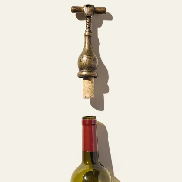 Mínima vista superior sacacorchos vintage con corcho descorchado y botella de vidrio para vino tinto, diseño conceptual para la lista de vinos sobre fondo beige. Tornillo de botella o abridor con sombras a la luz del sol, espacio de copia Imagen De Stock