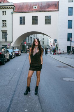 Gülümseyen genç kadın sokağın ortasında poz veriyor..