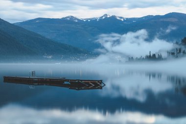 Nelson, BC, Kanada 'daki Kootenay Gölü üzerinde karamsar, atmosferik akşam sisi.
