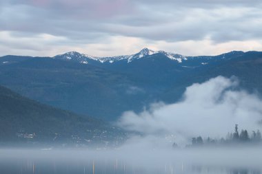 Nelson, BC, Kanada 'daki Kootenay Gölü üzerinde karamsar, atmosferik akşam sisi.