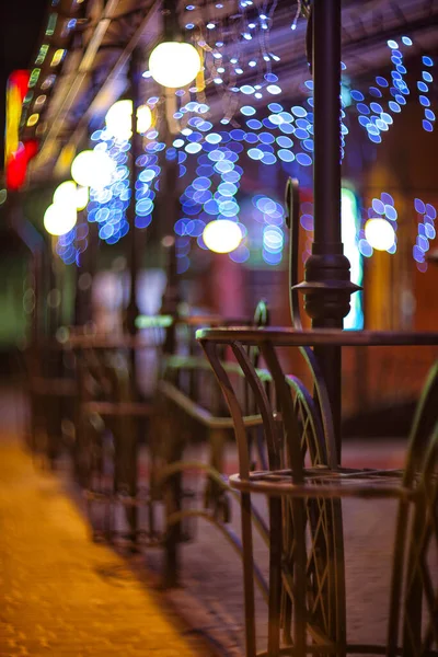 背景にはバーのフェンスやぼやけた夜のライトの装飾 市内のクリスマスの時間 要旨の背景 — ストック写真