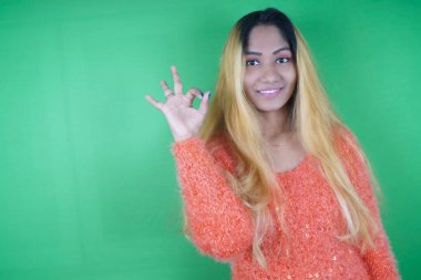 Yeşil arka planda el kol hareketi yapan güzel kadın Nikita Dev