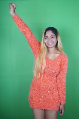 Yeşil arka planda dans eden gülümseyen kadın