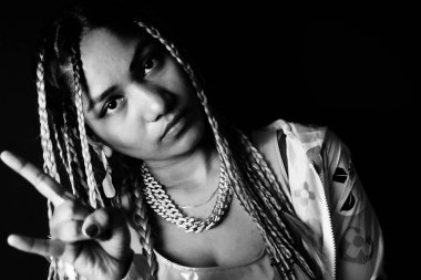 Young woman wearing braids showing rock and roll sign , Nikita Dev