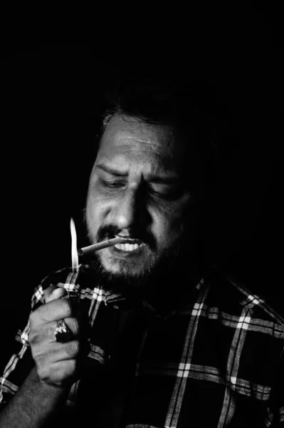 Smoker lighting cigarette over black background  , Santosh Kharat