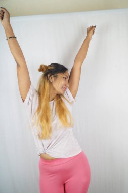 Beyaz arka planda gerinen gülümseyen kadın