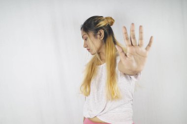 Kızgın kadın, beyaz arka planda dururken avuç içini gösteriyor.