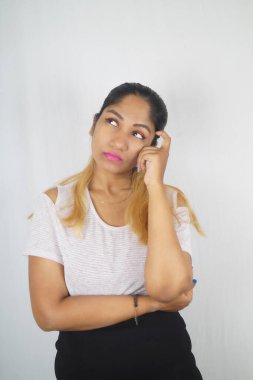 Düşünceli kadın beyaz arkaplanın önüne bakıyor.