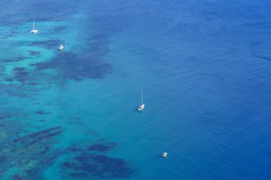 Şeffaf sularla denizde duran teknelerin havadan görüntüsü. Alicante Ara.