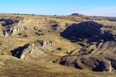 Dağların tepesinde vadileri ve küçük evleri olan çorak dağ manzarası..