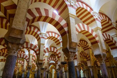 İspanya 'nın Cordoba kentindeki caminin içindeki sütunlarda birden fazla kemer ve doğal ışık parlaması.