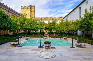 İspanya 'daki Cordoba Alcazar duvarının yanında fıskiyeler ve portakal ağaçları var..