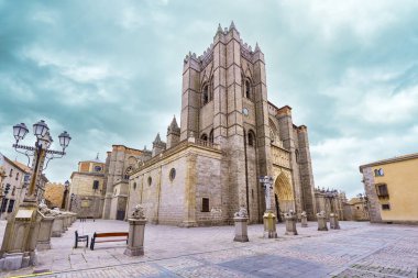 İspanya 'nın Avila şehrinde büyük gotik katedral bulutlu kış gökyüzüne yükseliyor..