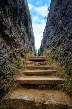 Yüksek dikey kaya duvarları arasında basamakları olan bir patika. Büyülü Şehir, Cuenca.